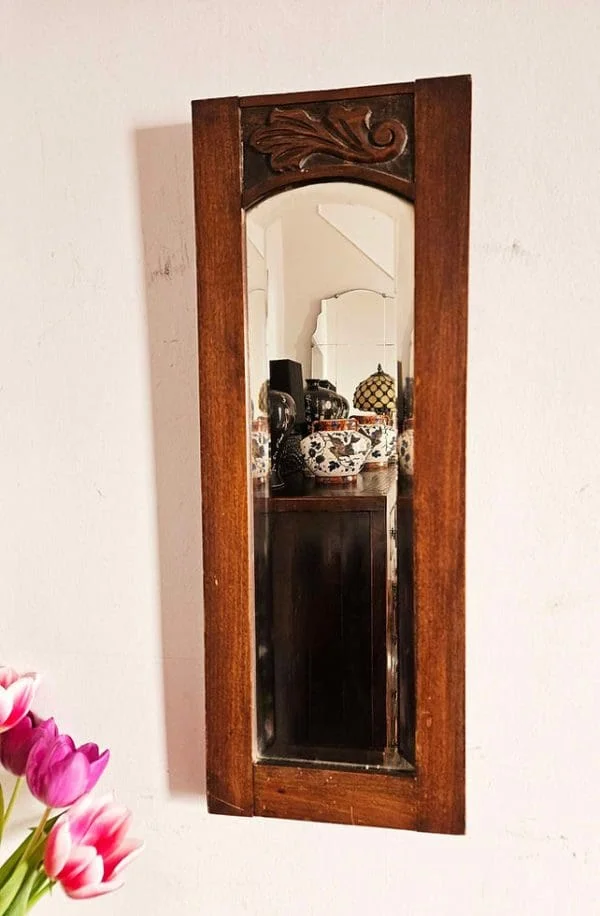 Antique narrow hall mirror with bevelled glass and carved oak frame